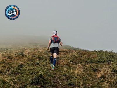 Trail runner climbing a foggy mountain ridge